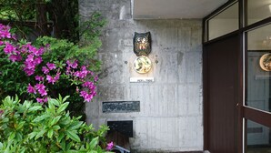 A concrete wall with a decorative owl plaque, a sign reading "MORI no YADO", and a small black plaque with Japanese characters. - Hakone Morinoyado (Hakone)