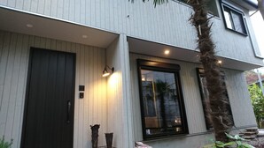 A modern two-story house with a dark front door, a large glass window, and a small porch area. - Hakone Morinoyado (Hakone)