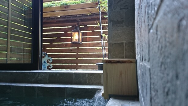 A stone wall with a wooden fence and a small water feature. - Hakone Morinoyado (Hakone)