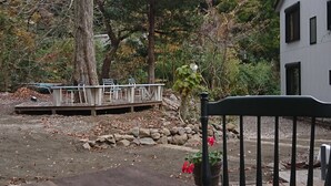 A dining table with breakfast items, a chair, and a view of a forested area with a building in the background. - Hakone Morinoyado (Hakone)