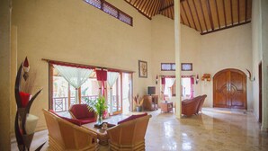 A spacious lobby with high ceilings, a wooden reception desk, and comfortable seating areas. - Teluk Indah Beach & Pool Villa (Tejakula)