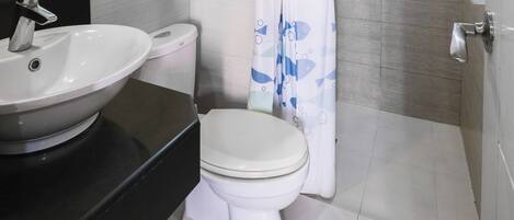 A bathroom with a white sink, toilet, and shower curtain.