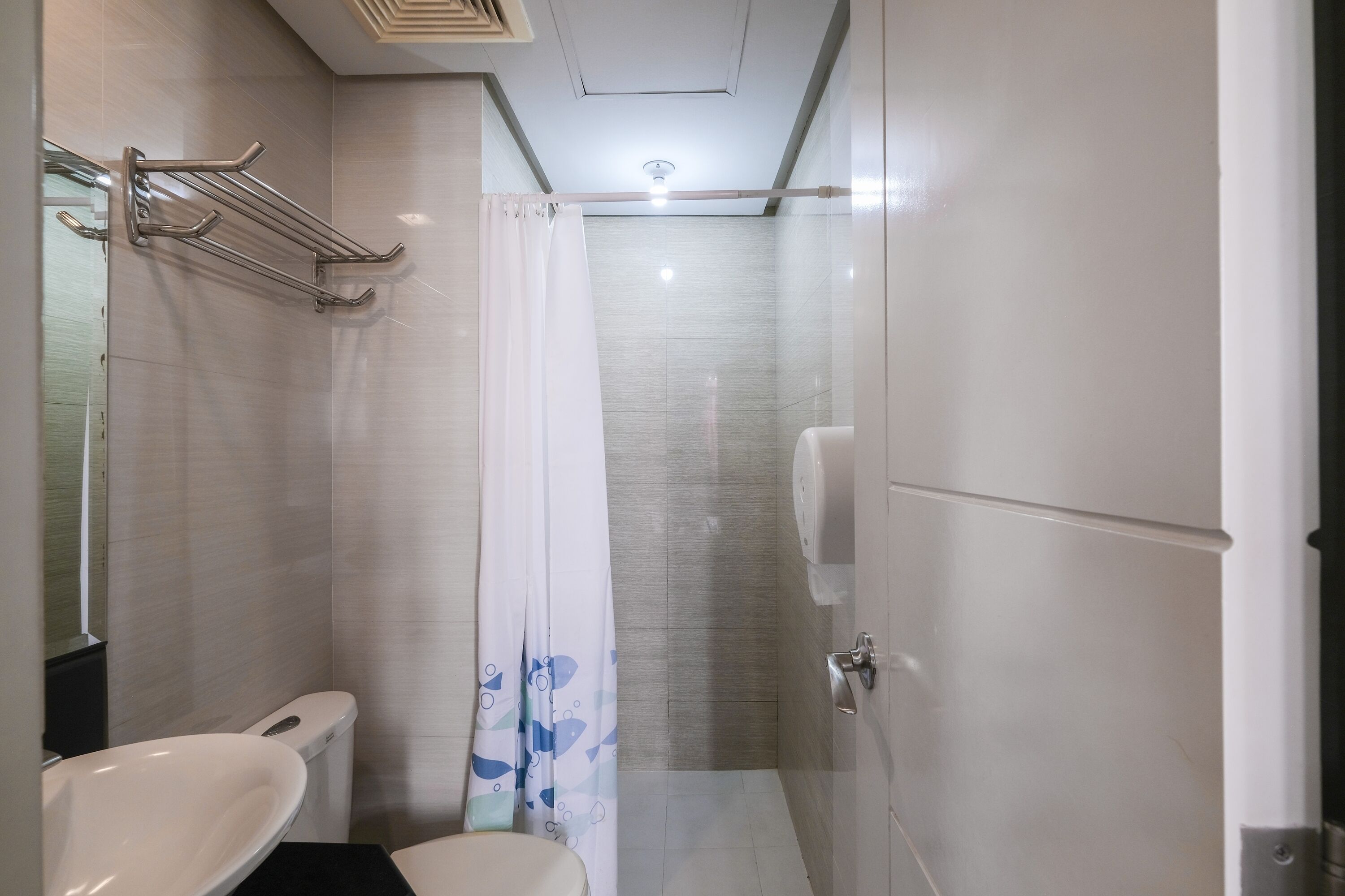 A modern bathroom with a white sink, toilet, and shower area.