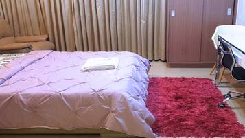 Un dormitorio con una cama, un escritorio y una silla.
