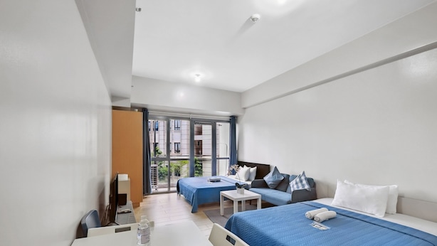 Une chambre d’hôtel avec un lit, un canapé, un bureau et une fenêtre.