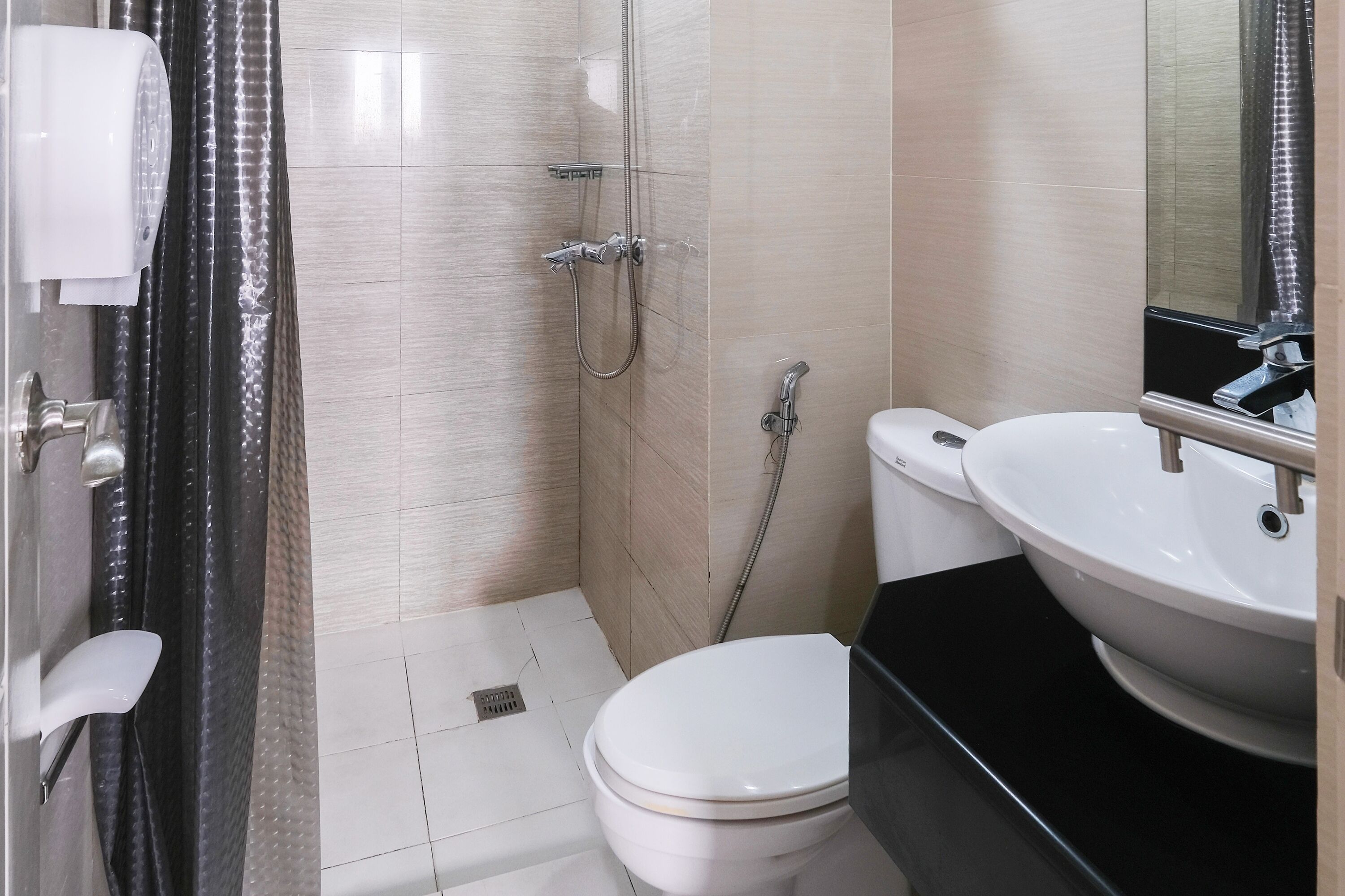 Ein Badezimmer mit Toilette, Waschbecken, Dusche und Spiegel.