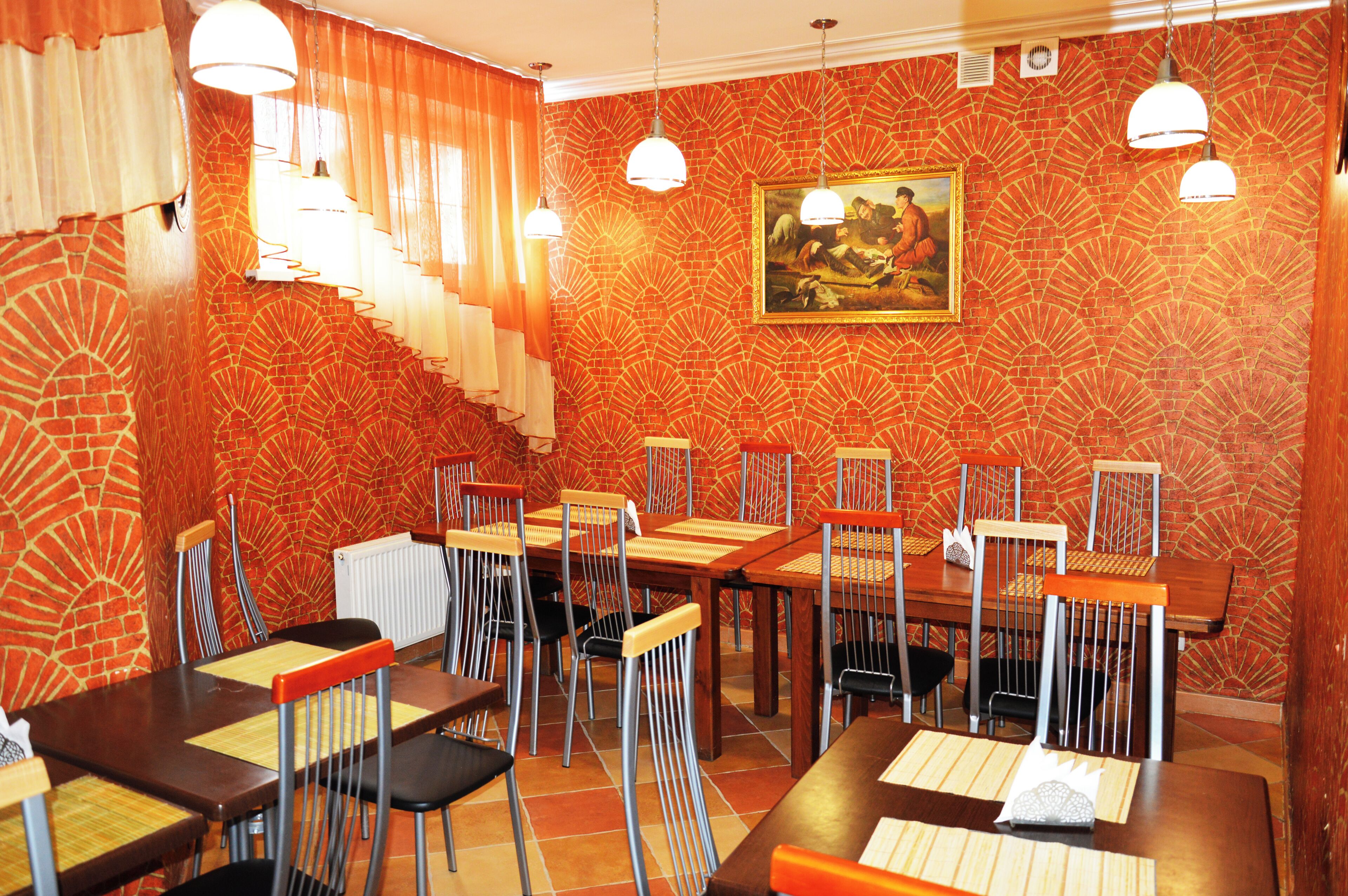 A restaurant with brick-patterned walls, multiple dining tables, and chairs.