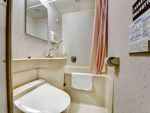 A bathroom with a toilet, sink, and shower area.