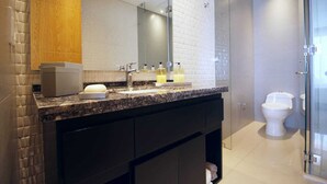Un baño moderno con encimera de mármol, un espejo grande y cabina de ducha de vidrio.
