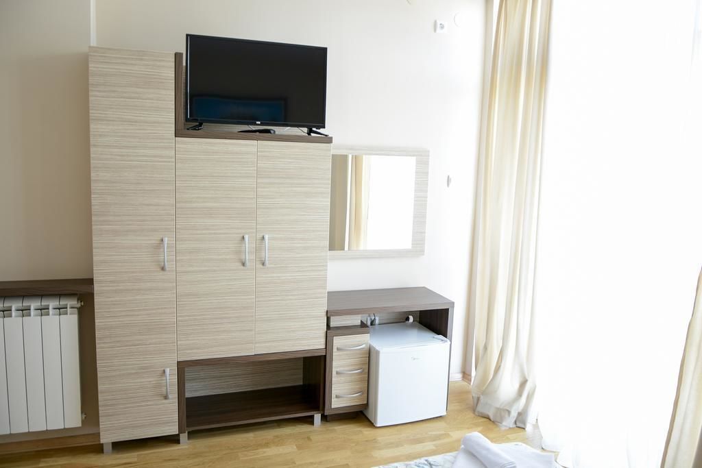 Ein Schlafzimmer mit Bett, Kleiderschrank, Schreibtisch und Fernseher.