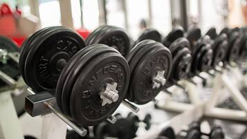A row of weight plates on a rack in a gym.