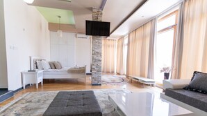 Una sala de estar moderna con sofá, una mesa de centro y una cama con cabecera.