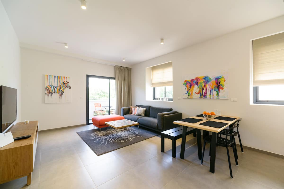 A modern living room with a sofa, coffee table, and dining area.