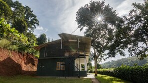 A two-story building with a staircase leading to an upper level. - Whispering Willows (Ootacamund)