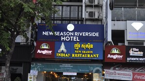 A hotel with a sign for 'New Season Riverside Hotel' and an 'Indian Restaurant' below it. - New Season Riverside Hotel (Phnom Penh)