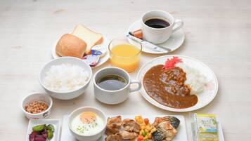 A breakfast spread with various food items and drinks on a table.