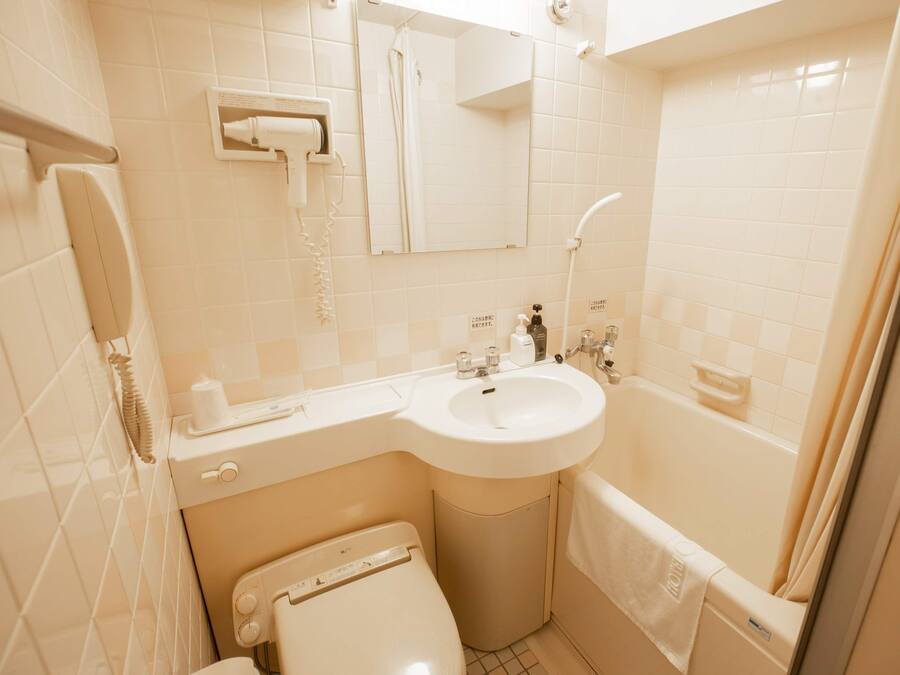 Baño con lavabo, espejo, toallero, inodoro y ducha.
