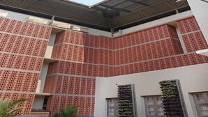 A building with a distinctive red perforated facade and a flat roof. - Treebo Casino (Kozhikode)