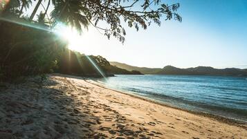 En privat strand, hvidt sand, badehåndklæder, massage på stranden