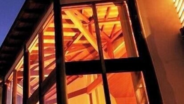 A building with large windows and a visible staircase leading to an upper level. - Izu Kogen no Kakure Yado Shuhari (Ito)