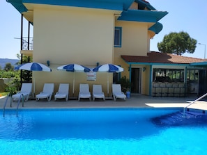 Alberca al aire libre por temporada y sombrillas en la alberca