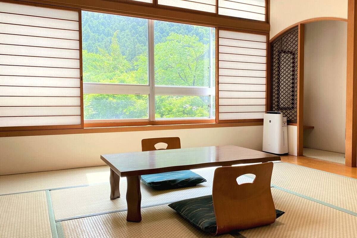 A traditional Japanese room with tatami flooring, a low table, and sliding doors.