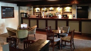 Een bar met houten meubels en een menubord.