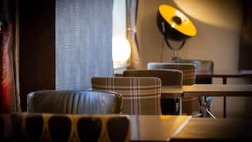 A dining area with a table and chairs, a lamp, and curtains.