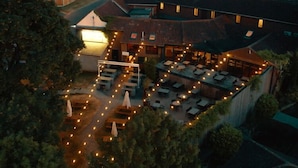 An outdoor dining area with tables and chairs, surrounded by a fence and trees. - The White Swan (Gainsborough)