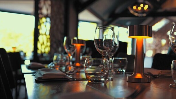A dining table set with wine glasses and a candle. - The White Swan (Gainsborough)