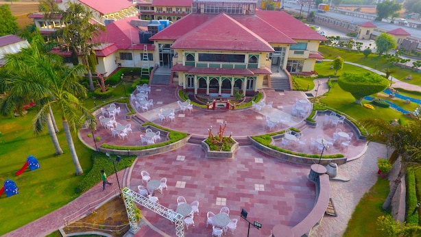 A hotel with a central courtyard, outdoor seating, and a playground. - Shiva Oasis Resort (Behror)