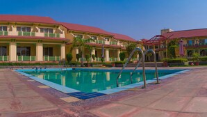 A hotel with a swimming pool, multiple balconies, and a red roof. - Shiva Oasis Resort (Behror)