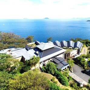 A coastal hotel with multiple buildings, a parking area, and a view of the sea. - Aburaya Annex Nagomitei (Ine)