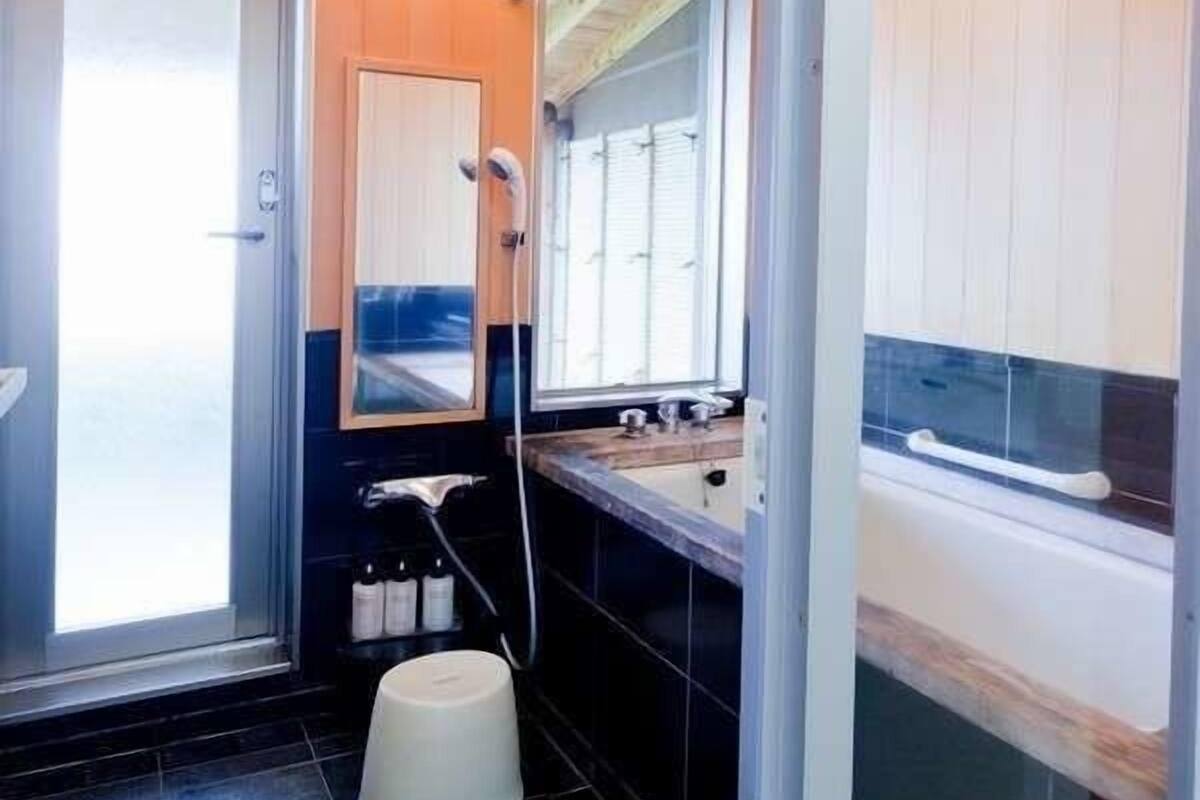 A bathroom with a shower, a sink, and a toilet.