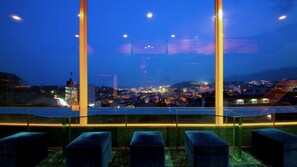 Un balcon donnant sur une vue panoramique de la ville la nuit.