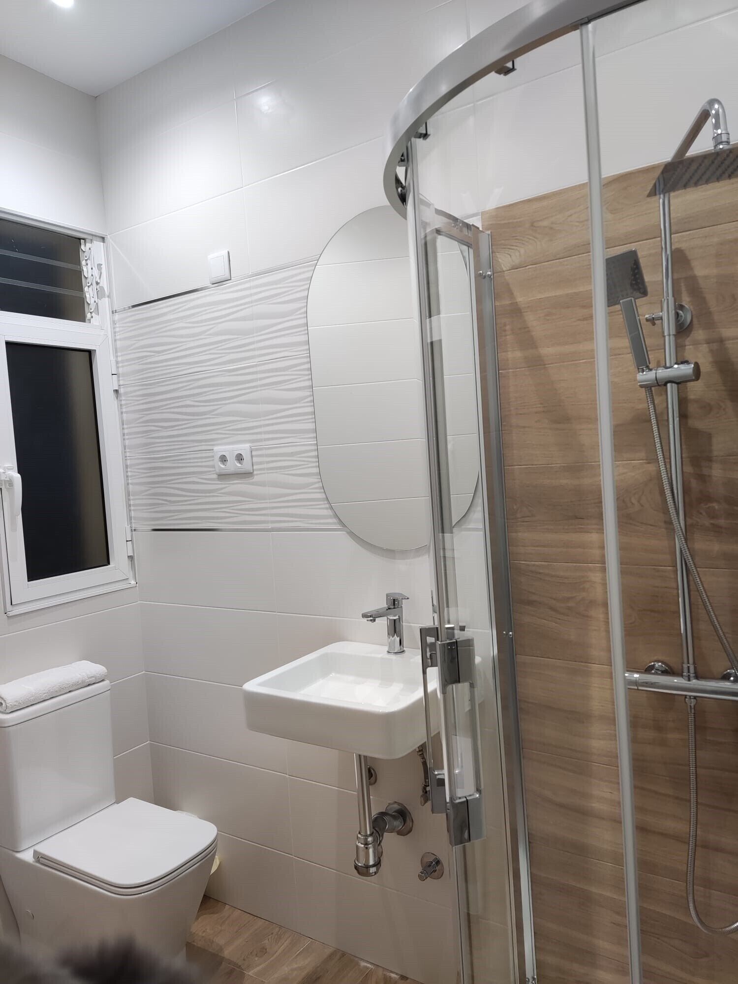 A modern bathroom with a toilet, sink, and shower.