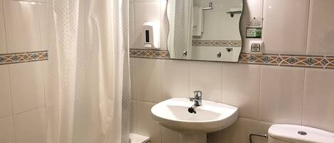 A bathroom with a bathtub, a sink, and a toilet.