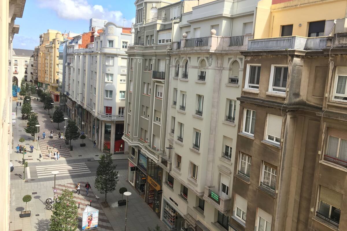 A multi-story building with a central courtyard, balconies, and a variety of storefronts.