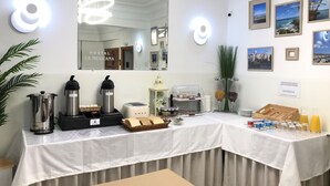 A hotel room with a breakfast bar, a coffee maker, a toaster, and a fruit display. - Hostal La Mexicana (Santander)