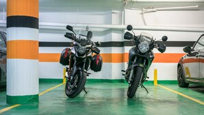 A parking garage with two motorcycles parked next to a pillar. - Hotel Sansi Park (Lleida)