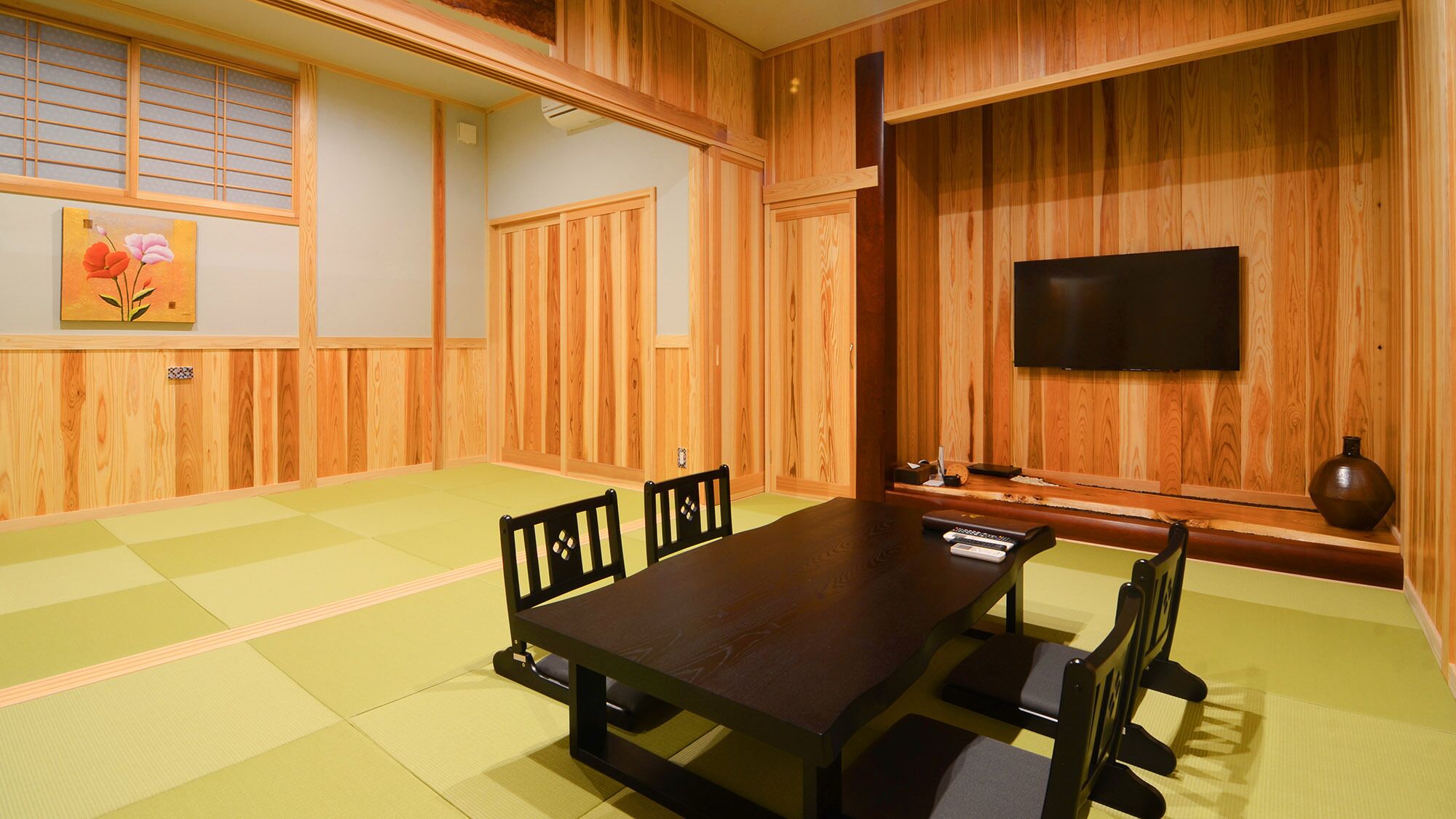 A traditional Japanese-style room with tatami flooring, a low table, and wooden sliding doors.