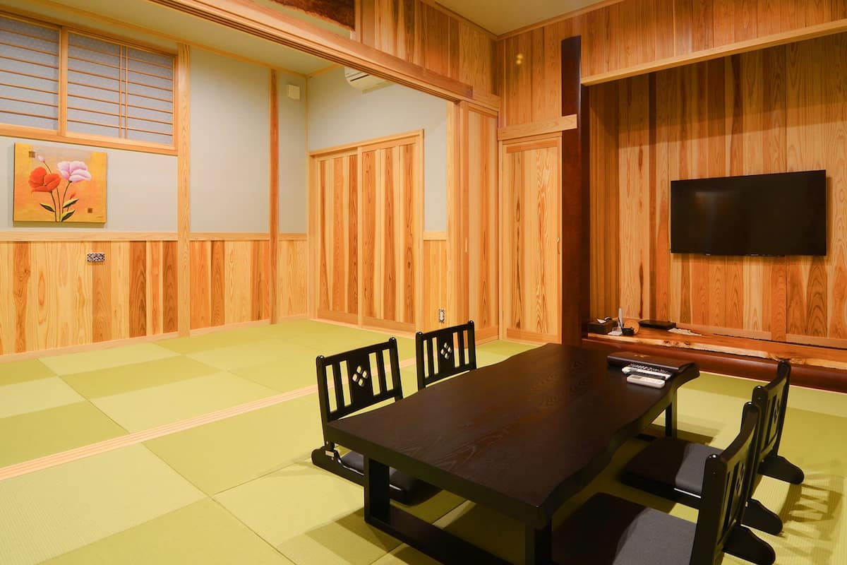 A traditional Japanese-style room with tatami flooring, a low table, and wooden sliding doors.