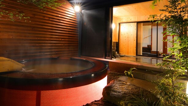 An outdoor hot spring with a wooden structure and a glass door entrance. - Shosei no Yado Shinan (Beppu)