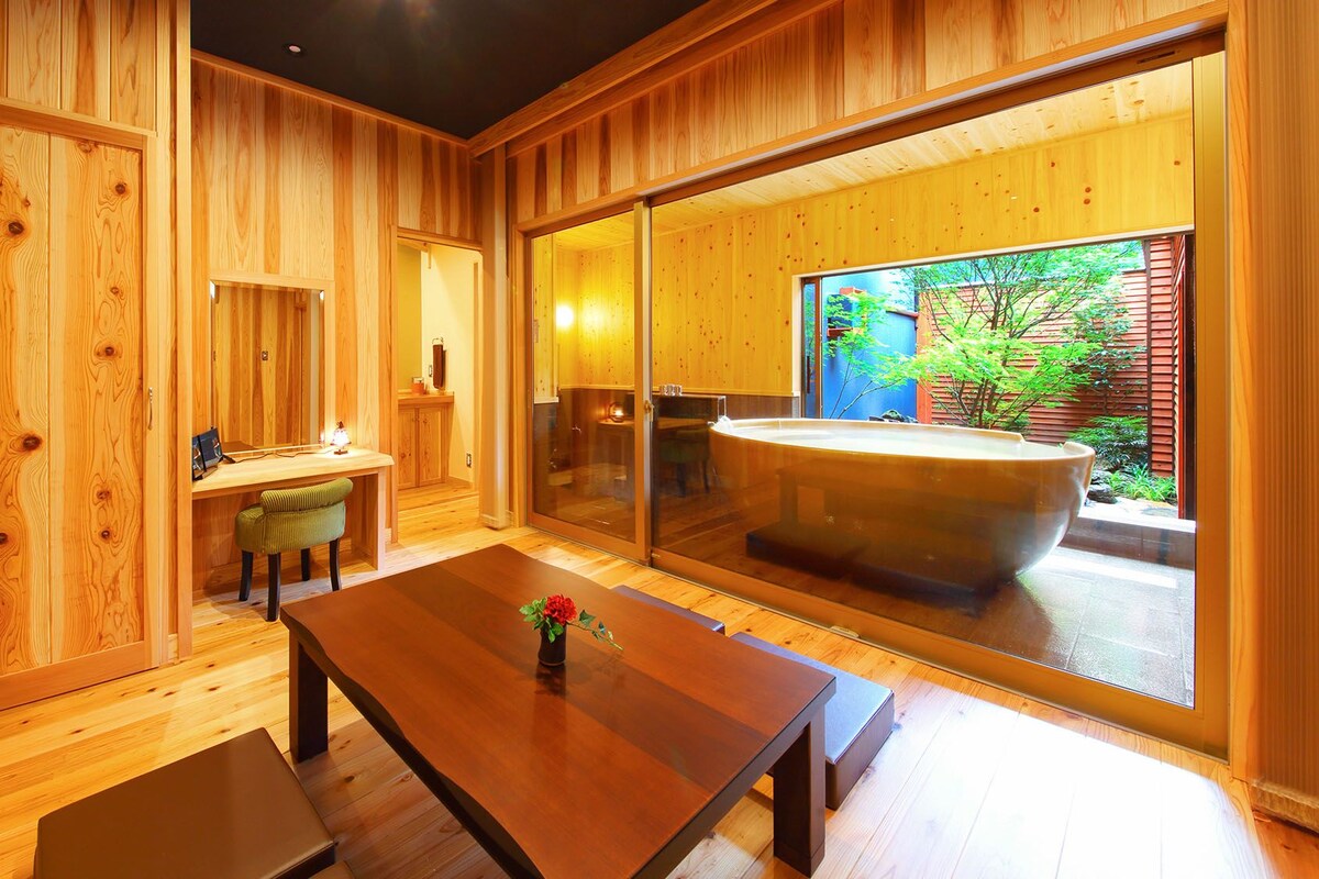 A wooden interior with a large sliding glass door leading to an outdoor hot tub area.