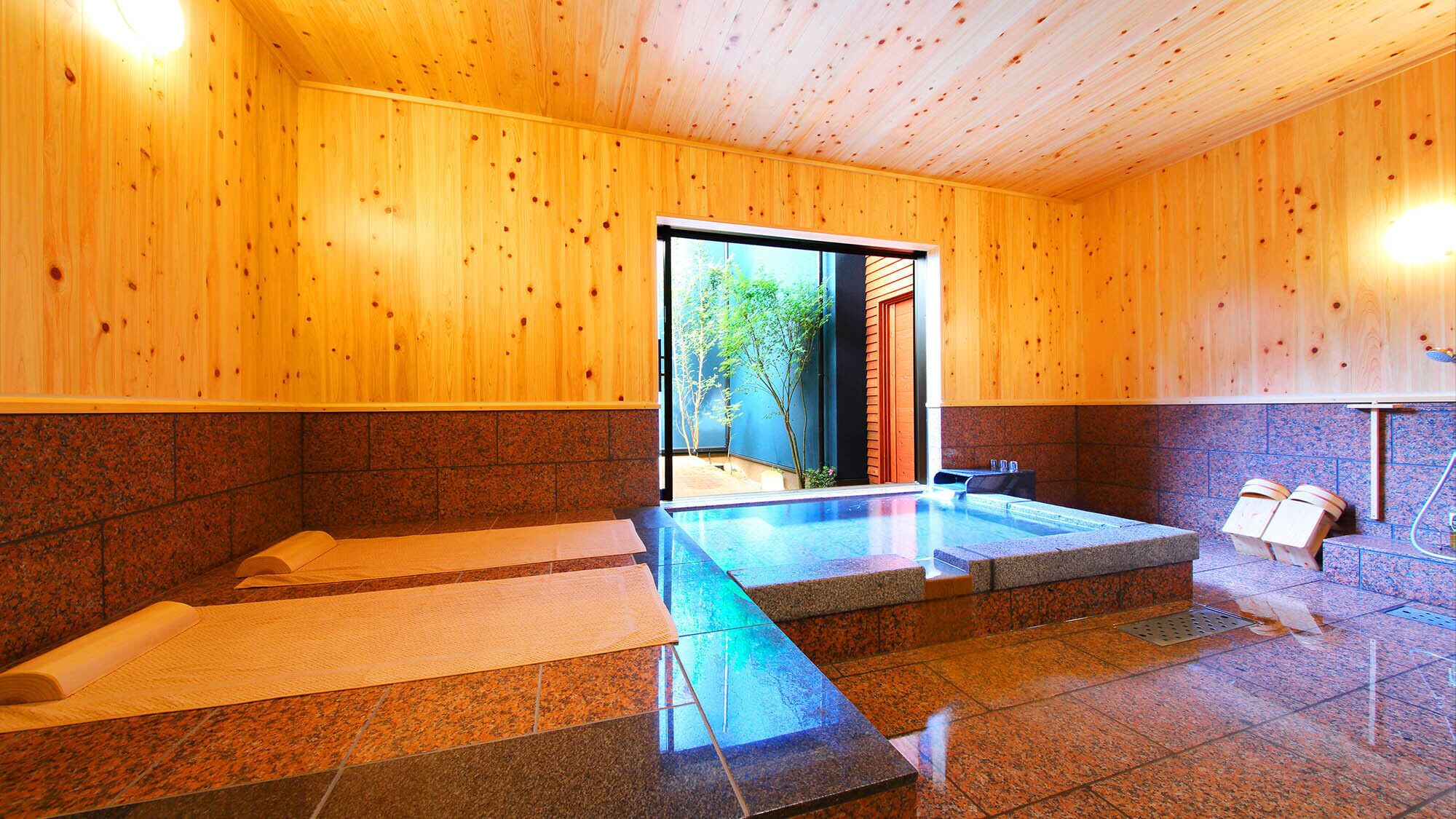 A wooden interior with a hot tub, stone flooring, and a view through a glass door.