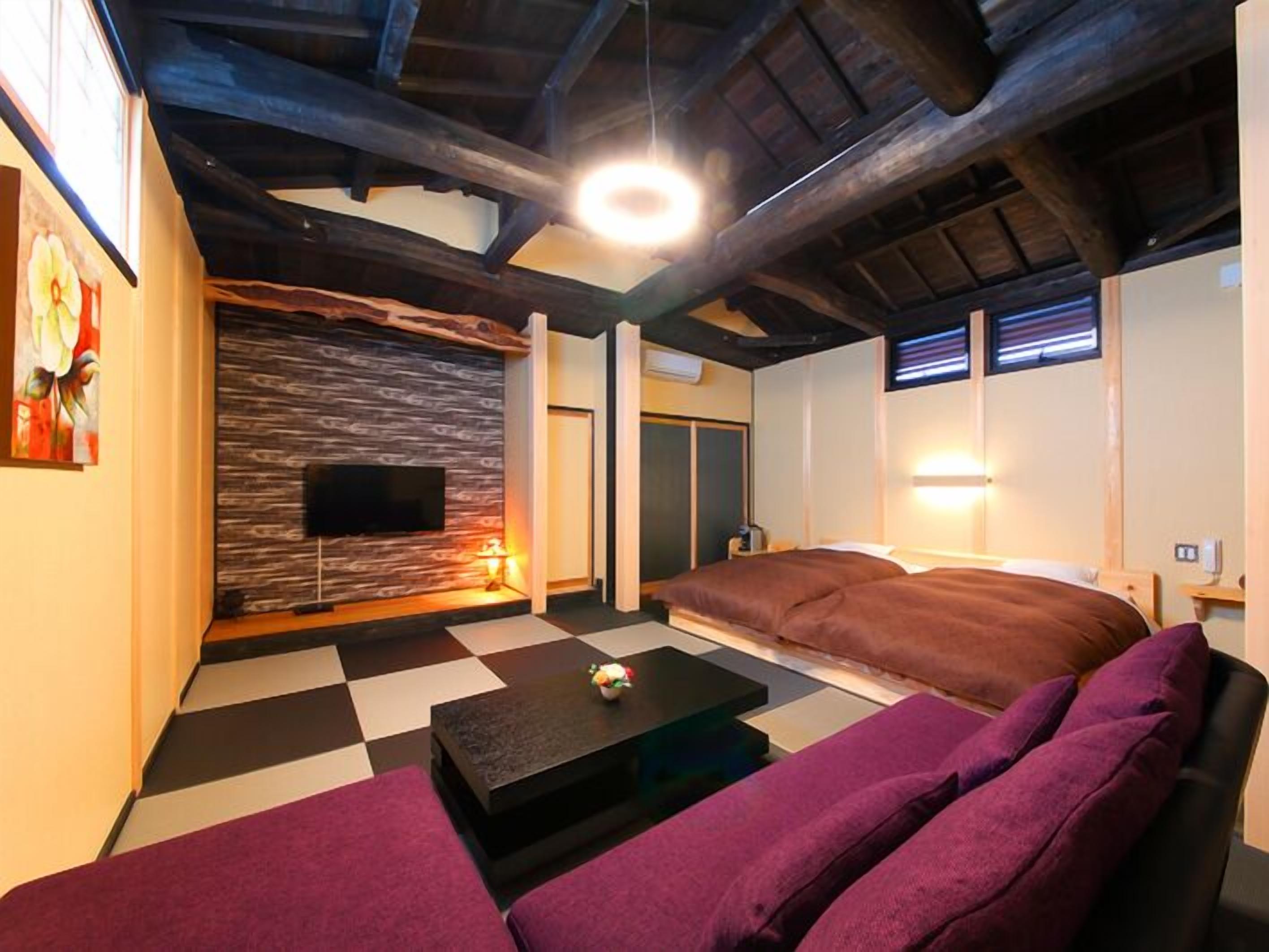 A modern living room with a checkered floor, a sofa, a coffee table, a flat-screen TV, and a wooden ceiling.