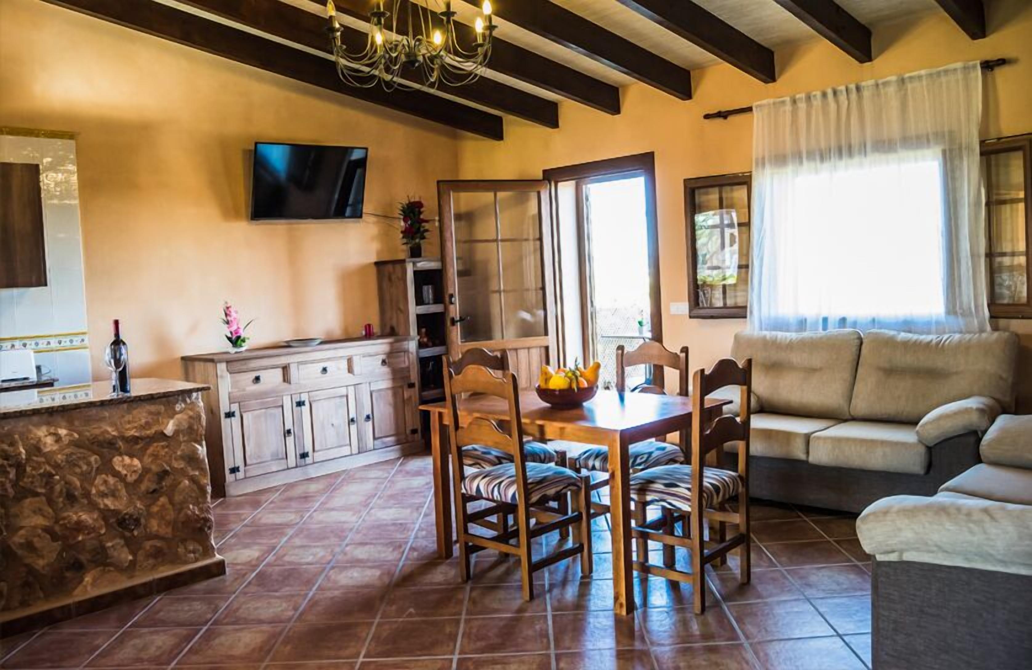 Uma sala de estar acolhedora com um sofá e uma área de jantar com mesa e cadeiras.