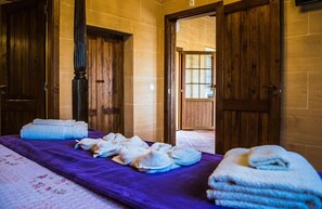 Une chambre avec un lit, des serviettes et des portes en bois.