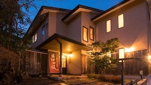 A two-story building with a covered entrance and a sign with Japanese characters. - Ayunokaze (Ito)