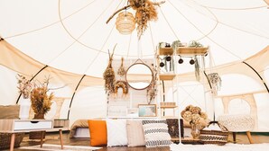 A cozy interior with a bed, a small table, and hanging decorations. - Calm Lanai Harbor (Nichinan)